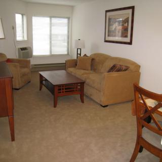 A cozy living room with a sofa, armchair, and coffee table.