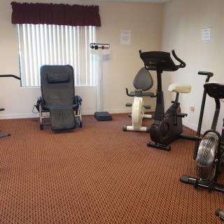 A small gym with various exercise equipment including stationary bikes and a scale.