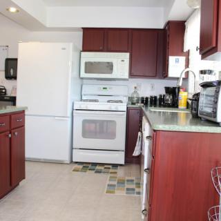 A modern kitchen with wooden cabinets and standard appliances.