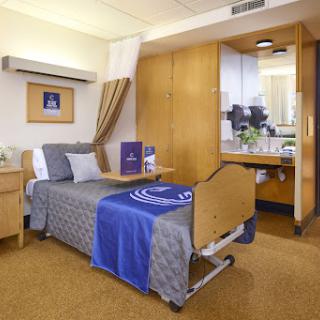 A well-furnished hospital patient room, designed for comfort and functionality.