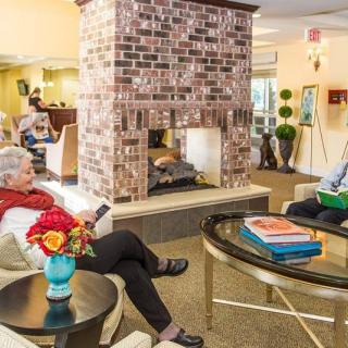 A cozy lounge area with a brick fireplace where people are relaxing and socializing.