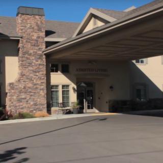 A building entrance with a covered driveway and stone chimney.
