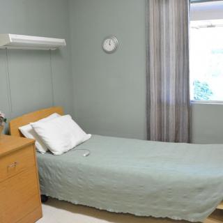 A minimalist hospital room with a single bed and a window, conveying a sense of cleanliness and simplicity.