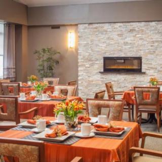 A cozy restaurant dining area with elegant table settings and a modern fireplace.