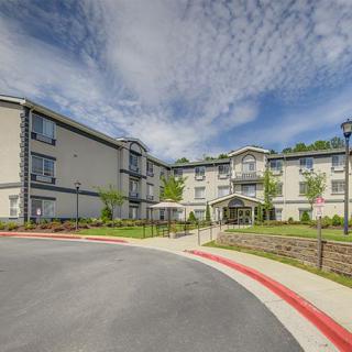 A modern residential apartment complex with a well-maintained exterior under a cloudy sky.