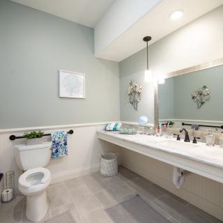 A modern, clean bathroom with a large mirror and stylish fixtures.