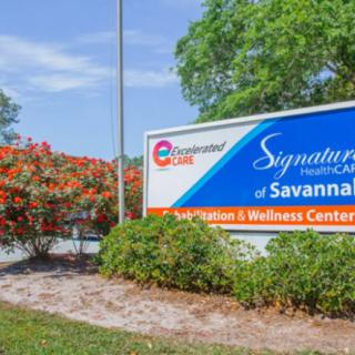 A sign for Signature Healthcare at Savannah's Rehabilitation and Wellness Center, surrounded by greenery.