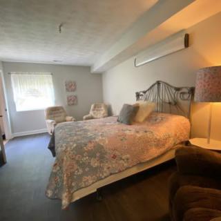 Cozy bedroom with a large bed, decorative pillows, and soft lighting.