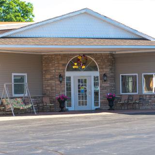 Front view of a building with a covered entrance and decorative elements.