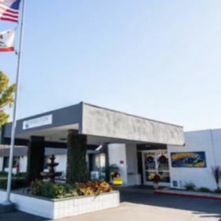 A building entrance with flags displayed outside on a sunny day.