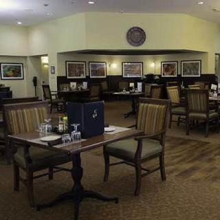 An empty dining area in a restaurant with neatly arranged tables and chairs.