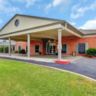 A brick building with a covered entrance and well-maintained landscaping.