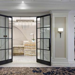 A luxurious reception area with glass double doors and elegant decor.