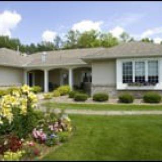 A suburban house with a well-maintained garden and lawn.