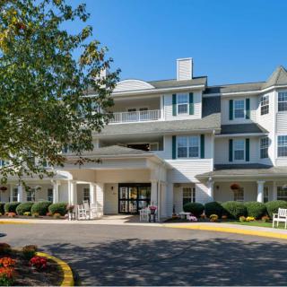 A sunny day view of a residential building with landscaped surroundings.