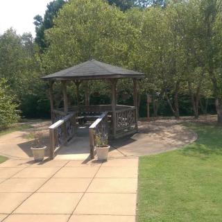 A tranquil park setting with a gazebo and small bridge.