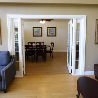 A view from the living room into the dining area, showcasing elegant furnishings and natural light.