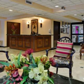 A welcoming lobby area with a reception desk, decorative furniture, and a floral centerpiece.