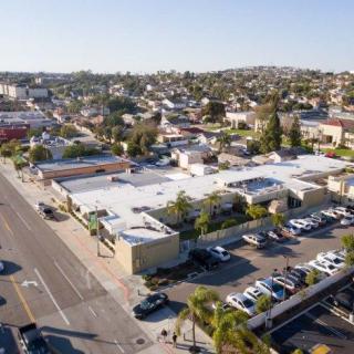 Aerial view of an urban area with buildings, roads, and parking lots in a residential neighborhood.