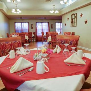 Elegantly set dining room with red tablecloths and neatly arranged napkins.