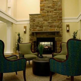Cozy seating area with a stone fireplace and comfortable chairs.