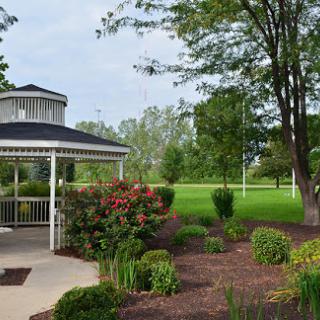 A serene gazebo surrounded by lush landscaping in a peaceful park.