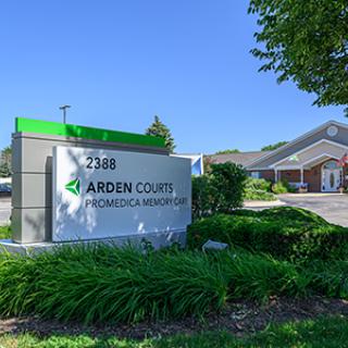 A view of the Arden Courts healthcare facility with a prominent outdoor sign and well-maintained landscaping.