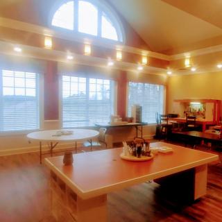 A cozy kitchen and dining area with warm lighting and large windows.