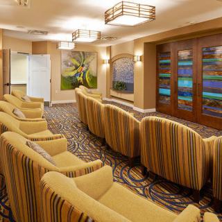A cozy theater room with comfortable seating, decorative lighting, and artwork on the walls.
