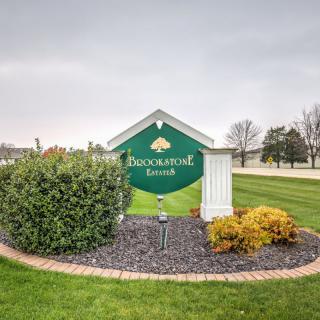 A welcoming sign for Duckwood Ranch surrounded by neatly arranged shrubs and plants.