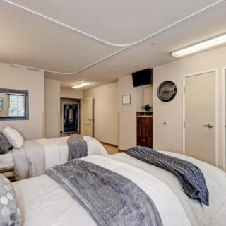 A neatly arranged bedroom with two beds and neutral-colored decor.