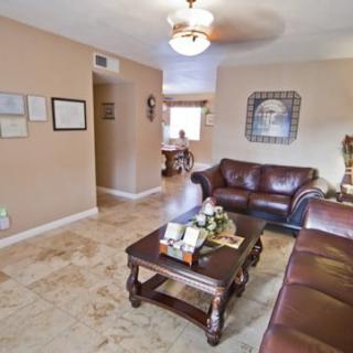 A cozy living room with leather sofas, a wooden coffee table, and decorative artwork on beige walls.