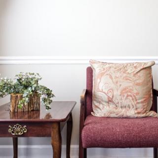 Cozy living room corner with a chair, table, and floral decor.