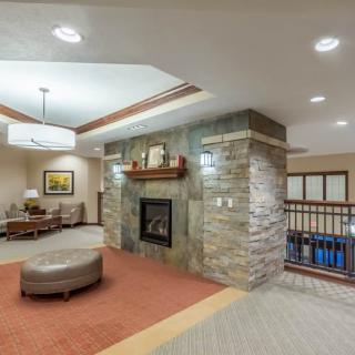 A cozy lobby interior with a stone fireplace and comfortable seating.