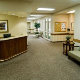 A spacious and welcoming lobby with a reception desk, seating area, and hallway.