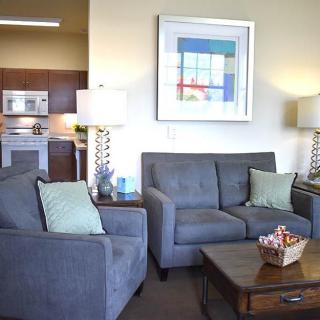 A modern living room with gray sofas, decorative pillows, and a wooden coffee table.