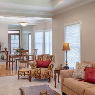 A cozy living room with adjoining dining area featuring comfortable furniture and warm lighting.