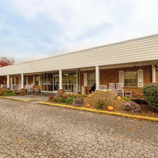 A view of a single-story commercial building featuring a welcoming entrance and landscaped surroundings.