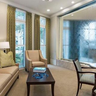 A modern living room with comfortable seating, including a sofa and armchairs, complemented by elegant window treatments.
