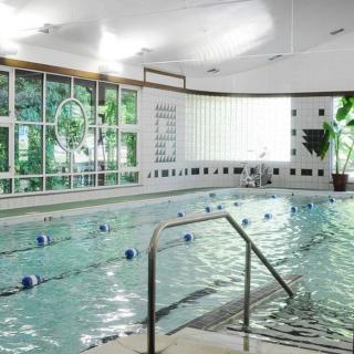 An inviting indoor swimming pool area with clear water and ambient lighting.
