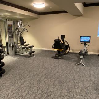 A gym with various exercise equipment including weights and machines.