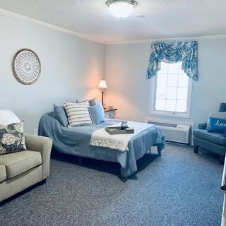 A cozy living room featuring a sofa, bed, and soft lighting.