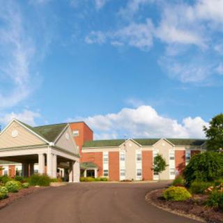 A healthcare facility with a brick exterior under a blue sky with clouds.