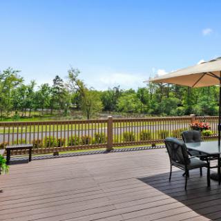 A serene outdoor deck with seating, overlooking a lush green landscape.