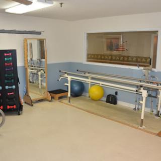 A well-equipped therapy room featuring exercise equipment and balance balls for rehabilitation.