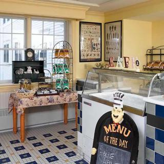 A cozy cafe interior featuring a menu board and dessert display cases.
