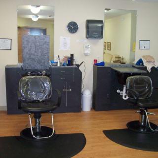 Interior of a barbershop with empty chairs and mirrors.