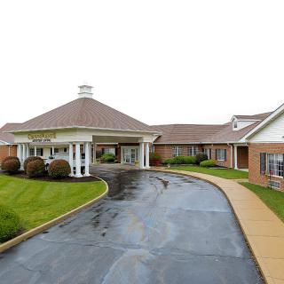 A well-maintained building with a circular driveway and landscaped surroundings.