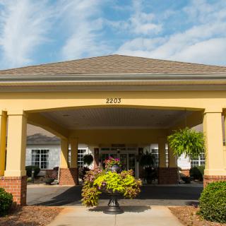 A building entrance with a canopy and surrounding landscaping.