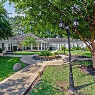 A well-maintained building surrounded by lush greenery and a winding pathway.